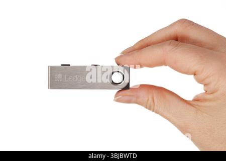 BRATISLAVA, SLOVACCHIA - 17 dicembre 2021: Portafogli di hardware cripto Ledger Nano S in mano isolati su sfondo bianco Foto Stock