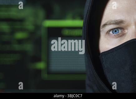Hacker in maschera nera. Concetto di hacking e sicurezza Internet Foto Stock
