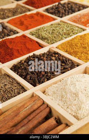 Scatola di legno con erbe e spezie diverse - pepe, paprika, cumino e altri Foto Stock