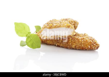Deliziose pepite di pollo dorate con erbe fresche isolate su sfondo bianco. Mangiare carne culinaria Foto Stock