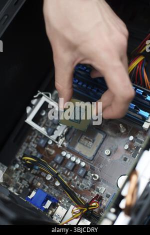 Tecnico informatico che installa la CPU nella scheda madre Foto Stock