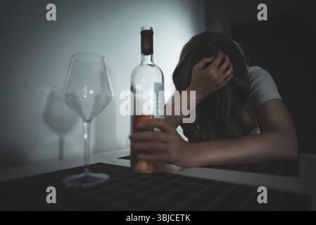 Donna che soffre di depressione e che beve alcol Foto Stock
