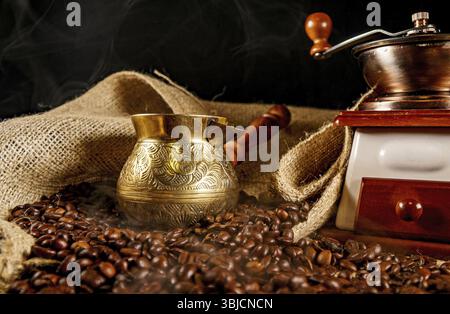 Macinacaffè vintage, cezve e chicchi di caffè Foto Stock