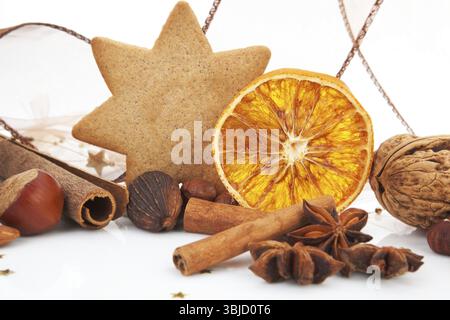 Tradizionale decorazione classica di natale. Pan di zenzero, cannella, varie noci e arancia. Festività marroni, natura morta Foto Stock