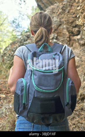 Donna con zaino che ama la natura. Vista posteriore Foto Stock