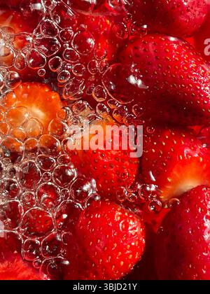 Fette di fragola fresche in acqua frizzante. Foto Stock