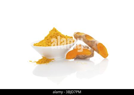 Curcuma, medicina tradizionale ayurvedica. Curcuma in polvere secca e radice fresca isolata su sfondo bianco Foto Stock