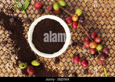 Background del caffè del commercio equo e solidale. Cofffea frutta, foglie, chicchi di caffè tostati dall'alto su sfondo di legno Foto Stock