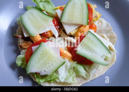 Preparazione di tortilla con pollo arrosto e vegetale Foto Stock
