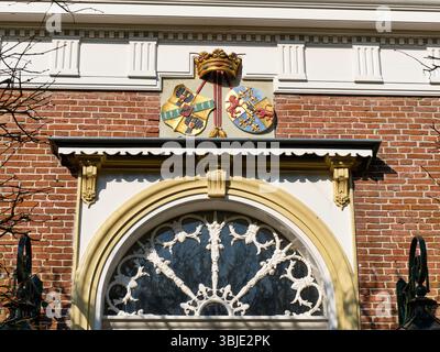 9 marzo 2025 - Leens-Paesi Bassi: Storico stemma dipinto con corona sopra la porta d'ingresso ornata di Borg Verhildersum, una nobile tenuta del Foto Stock