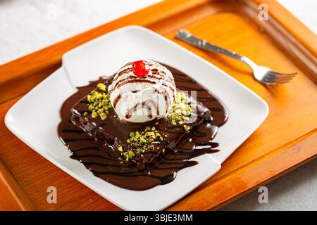 Torta al cioccolato fusa servita con pallina da gelato alla vaniglia, ricca e appagante. Foto Stock