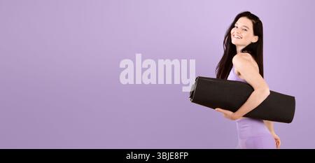 Pilates e Fitness. Giovane donna allegra con pelle di Vitiligo che trasporta il tappetino Yoga Foto Stock