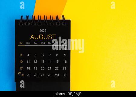 Mini calendario nero per agosto 2025 con sfondo multicolore. Foto Stock