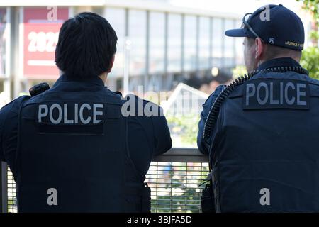 SALT LAKE CITY, UTAH – 15 GIUGNO 2025: Due agenti di polizia sorvegliano la folla alla protesta "No Kings", garantendo la sicurezza all'Università dello Utah. Foto Stock