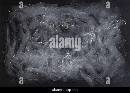 Macchie di acrilico bianco pastello sulla trama della carta nera, sfondo a motivi astratti Foto Stock