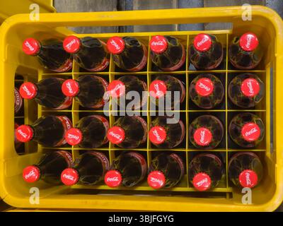 Germania Berlino 7 giugno 2025. Cassa contenente 24 bottiglie di Coca-Cola, fotografate dall'alto. I coperchi rossi contrastano con la cassa gialla delle bevande. Foto Stock