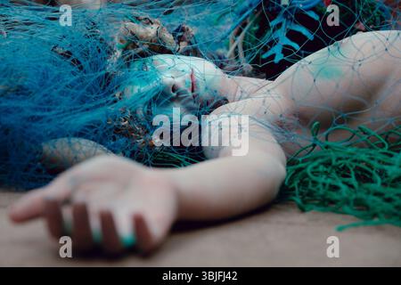 Londra, Regno Unito. 15 settembre 2021. Ocean Rebellion, un gruppo gemello di Extinction Rebellion, mette in scena un'azione teatrale fuori dal Department for Environment, Food and Rural Affairs (DEFRA), che si finge sirene morte catturate da reti da pesca per protestare contro la pesca a strascico, una tecnica di pesca che trascina le reti attraverso il letto dell'oceano distruggendo un ricco ambiente faunistico. Crediti: Joao Daniel Pereira/Alamy Live News Foto Stock