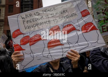 NEW YORK, NEW YORK - 14 GIUGNO: ?Una persona ha un cartello che cita il romanzo di George Orwell "1984" mentre decine di migliaia partecipano alla protesta del "No Kings Day"?, marciando lungo la Fifth Avenue il 14 giugno 2025 a New York, New York. Centinaia di marce e proteste? Nacque "negli Stati Uniti come parte di una "giornata nazionale di protesta pacifica" contro l'amministrazione Trump? e le sue politiche. La protesta nazionale arriva quando la parata militare del presidente Donald Trump che celebra il 250° anniversario dell'esercito degli Stati Uniti si svolge a Washington, DC. La parata di oggi coincide con il compleanno del presidente Trump. Foto Stock