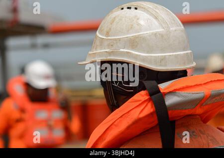 Abbandonare l'esercitazione navale a bordo della nave. L'equipaggio ha padroneggiato caschi e giubbotti di salvataggio per avere un addestramento simulando la situazione di emergenza Foto Stock