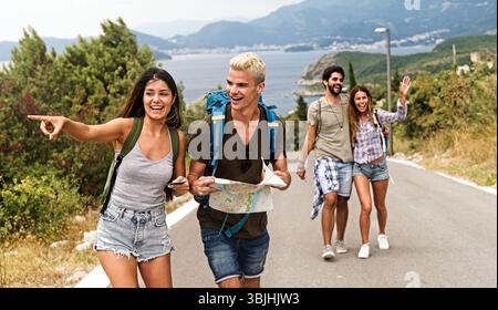 Concetto di amicizia, viaggio, vacanza, estate e persone. Gruppo di amici sorridenti con mappa in viaggio Foto Stock
