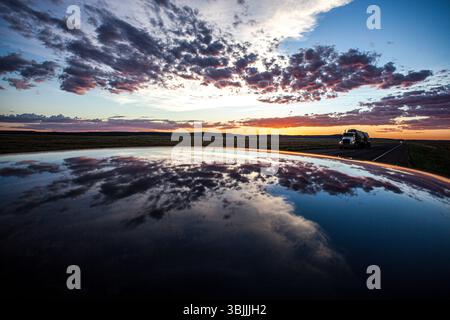 Nuvole al tramonto riflesse nel tetto del veicolo Foto Stock