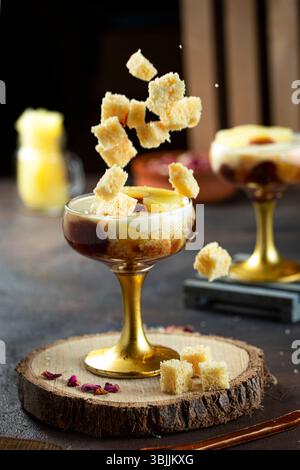 Dessert occidentale in un bicchiere con piccole fette di torta e strati di panna da latte. Foto Stock