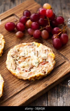 Mini quiche su fondo di legno con uva Foto Stock