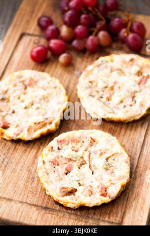 Mini quiche su fondo di legno con uva Foto Stock