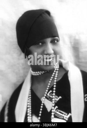 Questa fotografia del 1930 di Joséphine Baker, scattata da Paul Nadar, cattura l'iconica ballerina e cantante in un momento in bilico, mostrando la sua eleganza e il suo carisma distintivo. Baker era famosa per le sue esibizioni a Parigi durante gli anni '1920, dove divenne una figura influente nello spettacolo e nella cultura. Foto Stock