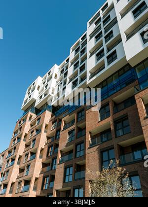 Architettura residenziale contemporanea con elementi in mattoni e vetro sotto un cielo azzurro e limpido nel sud della Spagna, ideale per immagini immobiliari, vita urbana e investimenti immobiliari. Foto Stock