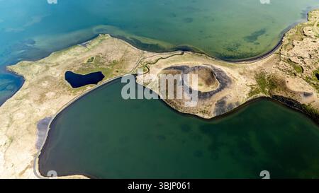 La vista aerea dei crateri Myvatn mette in mostra le formazioni vulcaniche uniche circondate da splendide acque blu, evidenziando le suggestive caratteristiche geologiche e la bellezza naturale delle Icelands durante il giorno. Foto Stock