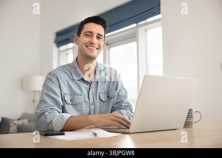 Ritrarre un giovane lavoratore freelance felice sul posto di lavoro domestico Foto Stock
