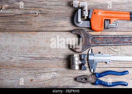 Ampia gamma di utensili idraulici su fondo in legno. Vista superiore con spazio di copia Foto Stock
