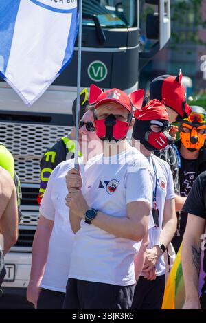 Partecipanti che indossano cappelli rossi di corno del diavolo e maschere protettive per il viso alla Parata dell'orgoglio di Varsavia a Varsavia, Voivodato della Masovia, Polonia. Giugno 2025 Foto Stock