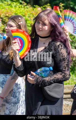 Due partecipanti vestiti di nero con tifosi arcobaleno alla parata del Warsaw Pride nel Voivodato della Masoviana, in Polonia, nel giugno 2025. Foto Stock