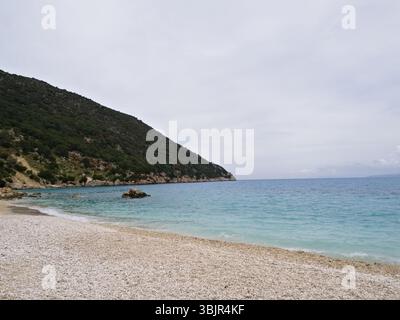 Spiaggia di Cefalonia con ghiaia bianca e cielo coperto in un tranquillo ambiente naturale costiero, perfetto per l'uso creativo. Foto Stock
