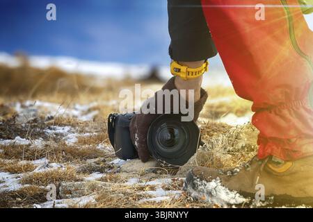 Uomo fotografo backpacker con telecamera e prendere foto. Stile di vita viaggio concetto hobby avventura vacanze attive outdoor Foto Stock