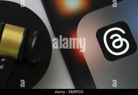 Dhaka, Bangladesh - 18 marzo 2025: Primo piano di uno schermo per iPad che mostra l'app thread accanto al martelletto di un giudice Foto Stock