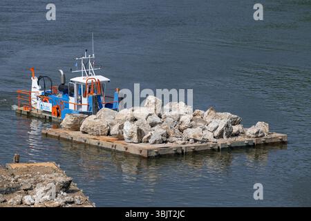 Villey-le-sec, Francia - Vista su una piccola barca a rimorchio spinge una chiatta carica per lavori fluviali sulla Mosella. Foto Stock
