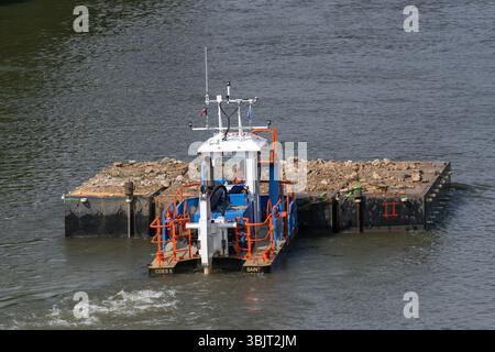 Villey-le-sec, Francia - Vista su una piccola barca a rimorchio spinge una chiatta carica per lavori fluviali sulla Mosella. Foto Stock