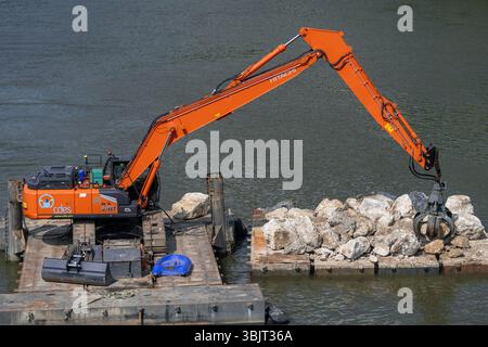 Villey-le-sec, Francia - Vista su un escavatore cingolato arancione Hitachi ZX350-7LC su una chiatta per lavori fluviali sul fiume Mosella. Foto Stock