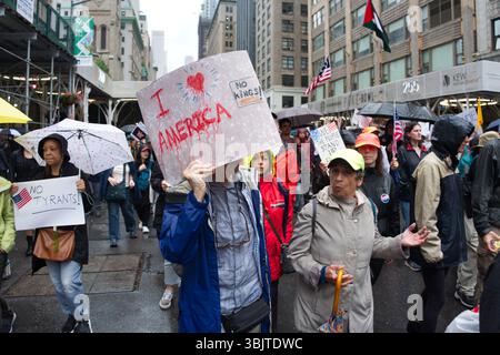 Una protesta in una strada di città in un giorno di pioggia. La gente ha dei segni con messaggi sull'America, la tirannia e i re. Molti portano ombrelli. Il segno principale rea Foto Stock