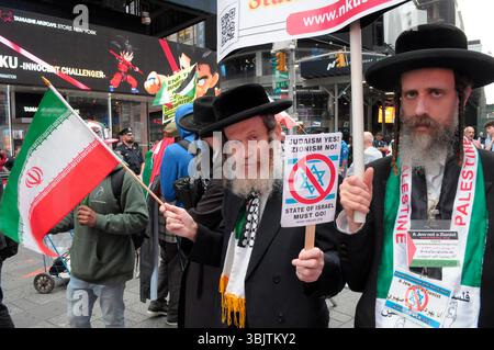New York, Stati Uniti. 16 giugno 2025. Membri di Neturei Karta che sono ebrei ultra-ortodossi e anti-sionisti, sventolano la bandiera iraniana e tengono dei cartelli a Times Square. I manifestanti in solidarietà con l'Iran si sono riuniti a New York, opponendosi agli attacchi aerei delle forze di difesa israeliane contro l'Iran. I manifestanti hanno anche condannato le operazioni militari dell'IDF a Gaza. Il raduno si è verificato mentre Israele e Iran hanno scambiato attacchi missilistici l'uno contro l'altro negli ultimi quattro giorni. I leader mondiali al vertice del gruppo dei sette o del G7 in Canada hanno discusso una soluzione al conflitto tra Israele e Iran. Credito Foto Stock