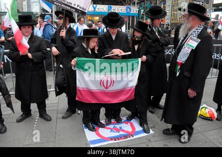 I membri di Neturei Karta che sono ebrei ultra-ortodossi e anti-sionisti, detengono la bandiera iraniana mentre calpestano una bandiera israeliana a Times Square. I manifestanti in solidarietà con l'Iran si sono riuniti a New York, opponendosi agli attacchi aerei delle forze di difesa israeliane contro l'Iran. I manifestanti hanno anche condannato le operazioni militari dell'IDF a Gaza. Il raduno si è verificato mentre Israele e Iran hanno scambiato attacchi missilistici l'uno contro l'altro negli ultimi quattro giorni. I leader mondiali al vertice del gruppo dei sette o del G7 in Canada hanno discusso una soluzione al conflitto tra Israele e Iran. (Foto di Jimin Kim / Foto Stock