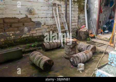 Un mucchio di legno e una scala sono davanti a un muro. Il legno è vecchio e ha un'atmosfera rustica Foto Stock