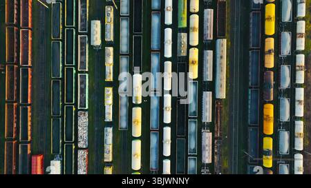 Vista aerea dei treni merci parcheggiati in uno scalo ferroviario. Uno scatto aereo di uno scalo ferroviario pieno di una serie organizzata di treni merci. Foto Stock