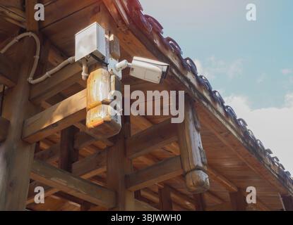 Telecamera di sorveglianza esterna su un antico edificio in legno. Telecamera di sicurezza CCTV nel parco forestale con messa a fuoco selettiva Foto Stock