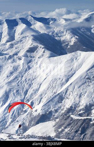 Parapendio sulle montagne innevate sopra la stazione sciistica nelle giornate di sole Foto Stock