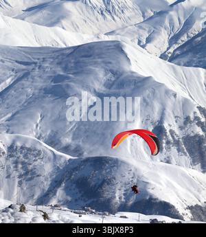 Parapendio sulle montagne innevate sopra la stazione sciistica Foto Stock