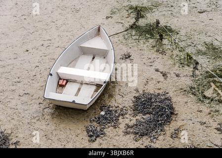 Barca bloccata con la bassa marea nel porto di Cancale Foto Stock
